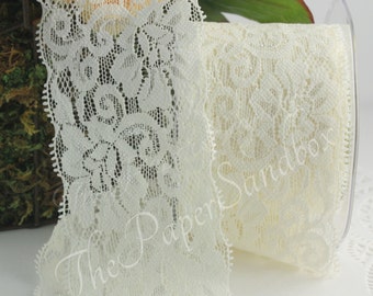 May include: Ivory lace ribbon on a spool. The ribbon features a floral pattern and a scalloped edge. The Paper Sandbox is printed on the ribbon. The ribbon is ideal for crafts, sewing, and embellishments.