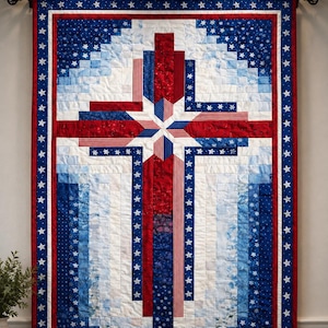 May include: A patriotic quilt with a cross design, featuring red, white, and blue fabrics. The quilt has a central cross shape with a starburst at the intersection, surrounded by a border of stars. The color scheme evokes the American flag.