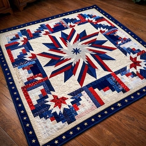 May include: A square quilt with a patriotic theme, featuring a central starburst design in red, white, and blue. The quilt has a cream-colored background with a blue border adorned with gold stars. The overall design is a log cabin style.