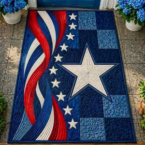 May include: A rectangular, quilted rug with a patriotic design. The rug features a large white star, white stars, and red and white stripes against a blue background. The design is reminiscent of the American flag.