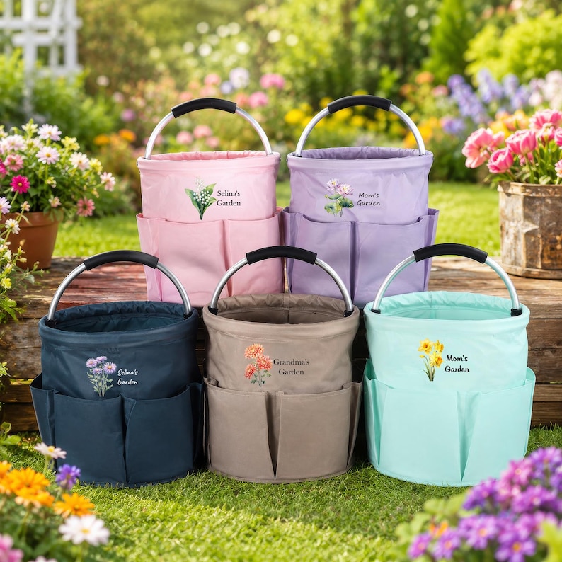 Puede incluir: Cinco bolsas de jard&iacute;n cil&iacute;ndricas de tela con asas de metal plateado y bolsillos exteriores. Cada bolsa presenta una ilustraci&oacute;n floral &uacute;nica y texto personalizado como Selina's Garden, Mom's Garden y Grandma's Garden en rosa, morado, azul marino, beige y verde azulado.