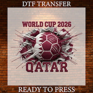 May include: A DTF transfer design featuring a soccer ball in maroon and white, with the text "WORLD CUP 2026 QATAR" in maroon. The design includes a brick wall background and the text "READY TO PRESS".