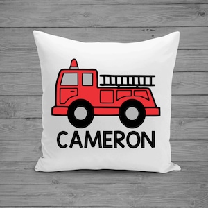 May include: White pillow with a red fire truck illustration and the name "CAMERON" in black text.