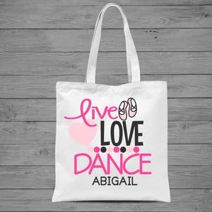 May include: White tote bag with a pink heart, pink ballet shoes, and the text "Live Love Dance Abigail".