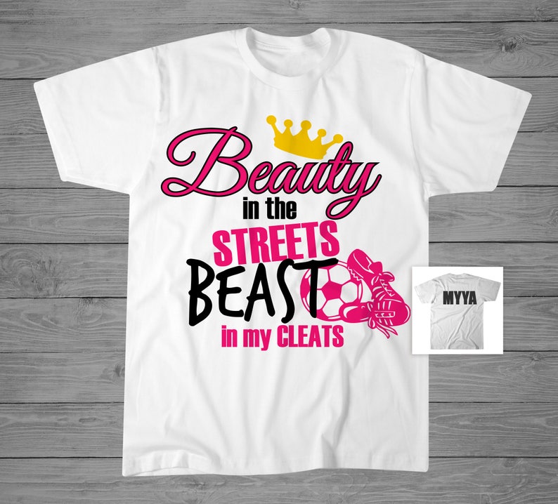 May include: White t-shirt with a pink and black graphic that says "Beauty in the Streets Beast in my Cleats" with a gold crown, soccer ball, and cleat. The back of the shirt says "MYYA".