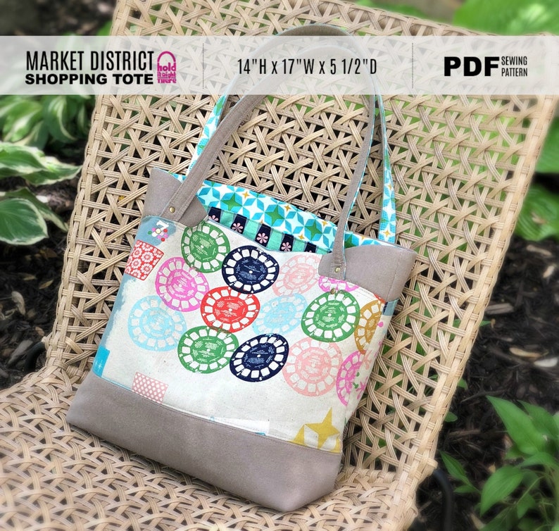 May include: A Market District Shopping Tote sewing pattern in PDF format. The tote bag is 14 inches high, 17 inches wide, and 5 1/2 inches deep. The tote bag is made of a white fabric with a colorful pattern of circles. The tote bag has brown leather handles and a brown leather bottom.