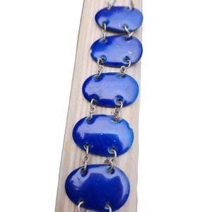 May include: A blue enamel bracelet with oval-shaped links connected by silver chains.