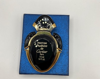 May include: Black perfume bottle with gold trim, resting on a blue box. The bottle has a unique shape and features the text "PARFUM Panthère de Cartier Paris 7.5 ml 1/4 fl. oz."