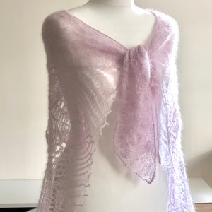May include: A delicate, light purple knitted shawl with a lacy pattern. The shawl is draped over a white mannequin.