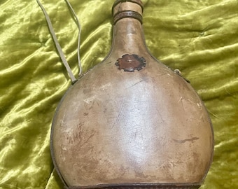 Decantador de vino antiguo con cuero aplicado y trabajado a mano, firmado por Lena Avilia.