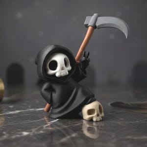 Op de afbeelding: Een kleine, zwarte Grim Reaper-figuur met een witte schedel en een zwarte capuchon. De figuur houdt een zeis vast met een houten handvat en een zilveren blad. Een tweede schedel rust op de grond. De achtergrond is donkergrijs.