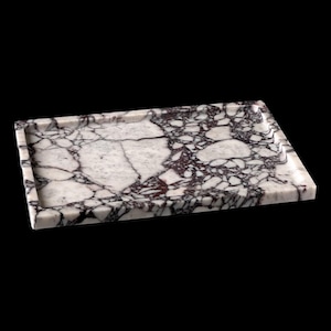 May include: A rectangular marble tray with a white and purple veined pattern. The tray has a raised edge and a smooth surface. The marble has a polished finish and is set against a black background. This tray is suitable for serving or display.