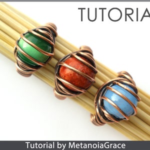 Op de afbeelding: Drie draadgewikkelde ringen met verschillende gekleurde stenen. De ringen zijn gemaakt van koperdraad en hebben groene, oranje en blauwe stenen. De ringen worden gepresenteerd op een houten oppervlak. Tutorial door MetanoiaGrace.