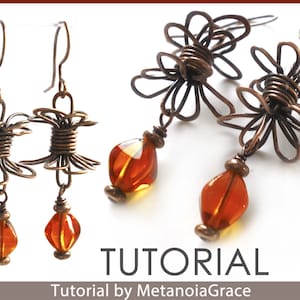 May include: A pair of copper wire earrings with amber glass beads. The earrings are shaped like a flower with a twisted wire centre. The earrings are hanging from a silver hook.
