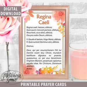 May include: Printable prayer card with a floral design and the text "Regina Caeli" in a gold frame. The prayer text is in Latin and includes the words "alleluia" and "Oremus".