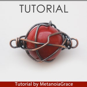 Puede incluir: Una cuenta de piedra roja est&aacute; encerrada en una jaula de alambre hecha de alambre de cobre. La jaula de alambre tiene un bucle en cada extremo para sujetarla a un collar o pulsera. Tutorial de MetanoiaGrace.