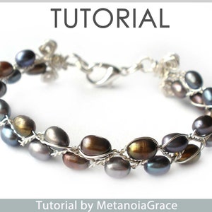 May include: A silver wire wrapped bracelet with a clasp fastening. The bracelet features a double row of dark grey, brown, and iridescent pearls.