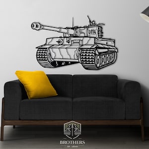 May include: Black metal wall art depicting a tank with a long barrel and detailed treads. The tank is mounted on a white wall above a black sofa with a yellow cushion. The artwork is a detailed outline of the tank.