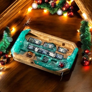 Pode incluir: Uma bandeja de madeira com um inserto de resina verde, que apresenta múltiplos slots para guardar objetos pequenos. A bandeja tem um acabamento de madeira natural e é decorada com um padrão de redemoinho verde e branco.