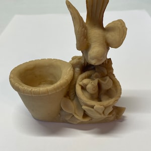 Peut inclure: Figurine beige repr&eacute;sentant un oiseau au-dessus d'un nid avec trois oisillons et un petit panier. Le panier est sur le c&ocirc;t&eacute; gauche de la figurine. La figurine est faite d'un mat&eacute;riau lisse.