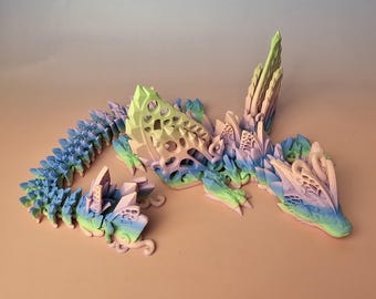 May include: A 3D-printed dragon figurine in pastel colors. The dragon features a segmented body, intricate detailing, and a crystalline structure. The color palette includes shades of blue, green, yellow, and pink, creating a whimsical and fantasy-themed aesthetic.