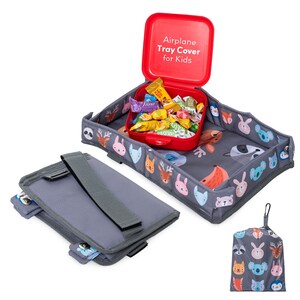 May include: A gray airplane tray cover for kids with a red container filled with candy. The tray has a colorful animal face pattern. A gray storage pouch and a matching drawstring bag are also included.