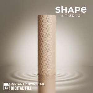 May include: A beige cylindrical object with a textured surface, resembling scales, is partially submerged in water, creating ripples. The object is centered in the image, with the text "SHAPE STUDIO" in white letters at the top.