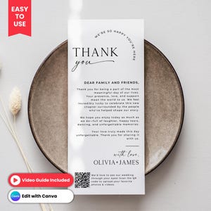 May include: A white wedding thank you card with black text, including "THANK you" in a script font. The card includes a message to family and friends, and is on a brown plate. The card also has a QR code.