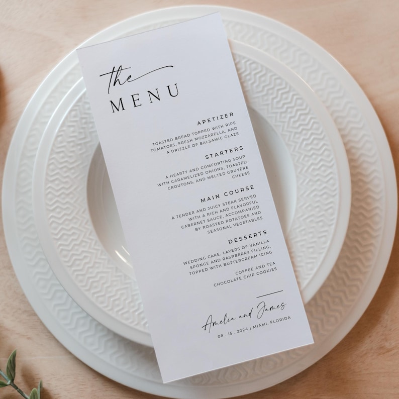 May include: A white menu card with black text listing the appetizers, starters, main course, and desserts for a wedding reception. The menu includes items like toasted bread with mozzarella, a hearty soup, steak, wedding cake, and chocolate chip cookies. The bottom of the card reads "Amelia and James 08-15-2024 Miami, Florida."