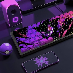 May include: A gaming setup with a black keyboard, illuminated by purple and pink backlighting. A matching speaker and a phone case with a purple floral design are also present. A purple sphere and a black monitor are in the background.