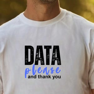 Könnte beinhalten: Weißes T-Shirt mit dem Text "DATA please and thank you" in Schwarz und Blau. Das Shirt hat einen Rundhalsausschnitt und scheint aus einem weichen Material zu sein. Der Text ist mittig auf der Vorderseite des Shirts platziert.