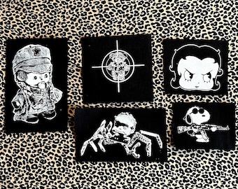 Simpatiche toppe in tela con personaggi dei cartoni animati: Bettie Boop, Monchichi, Joe Cool Snoop, disegni di giocattoli.