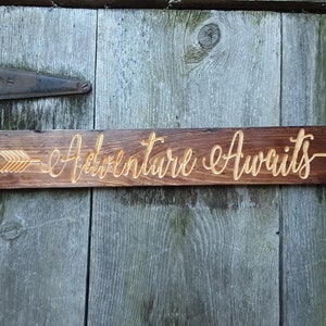 Adventure Awaits Holzschild geschnitzt dunkel gebeizt mit natürlichem Schriftzug und Pfeil
