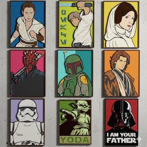 May include: Nine framed art prints featuring characters from a science fiction film series. The prints showcase characters like Darth Vader, Yoda, and Boba Fett, each with a unique color scheme and design. The text "I AM YOUR FATHER" is visible on one print.