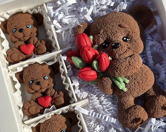 May include: A white gift box filled with shredded white paper and four brown teddy bears. One bear is holding a bouquet of red tulips. Each bear is holding a red heart.