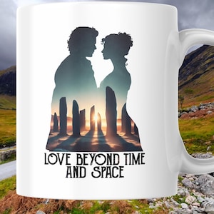 Może przedstawiać: Biały ceramiczny kubek z sylwetką pary na tle zachodu słońca i formacji skalnej. Kubek ma czarny napis "LOVE BEYOND TIME AND SPACE". Kubek ma zakrzywiony uchwyt.