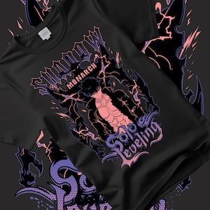 May include: Black t-shirt featuring a graphic design with the words "Shadow Monarch" and "Solo Leveling". The design includes a stylized illustration of a character with a muscular physique, surrounded by lightning and dark shapes.