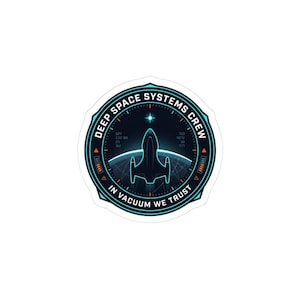 May include: A sticker with a circular design featuring a spaceship silhouette and the text "DEEP SPACE SYSTEMS CREW" and "IN VACUUM WE TRUST". The design is primarily teal and orange on a white background.