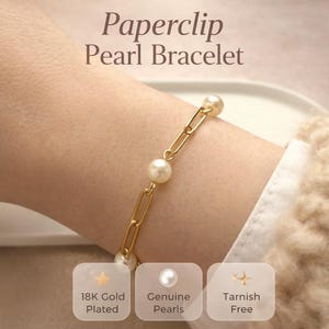 May include: A gold paperclip-style bracelet with genuine pearls. The bracelet is shown on a wrist, with the text "Paperclip Pearl Bracelet" at the top. The bracelet is 18K gold plated and tarnish free.