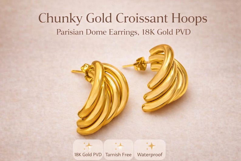Puede incluir: Un par de pendientes de aro dorados con forma de croissant. Los pendientes son de PVD de oro de 18K, resistentes al deslustre e impermeables. El texto de la imagen dice "Chunky Gold Croissant Hoops" y "Parisian Dome Earrings, 18K Gold PVD."