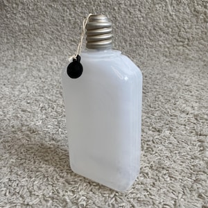 May include: A set of three ceramic mugs with a speckled, matte finish. The mugs are in shades of cream, light gray, and dark gray. Each mug has a simple, minimalist design and a rounded handle. The mugs are suitable for coffee, tea, or other beverages.