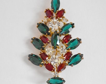 May include: A gold-tone Christmas tree brooch with red, green, and clear rhinestones.