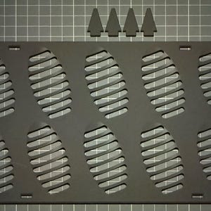 May include: A black rectangular 3D printer bed with ten oval-shaped vents and four triangular pieces. The bed has a grid pattern in the background. The Bambu logo is visible in the top left corner.