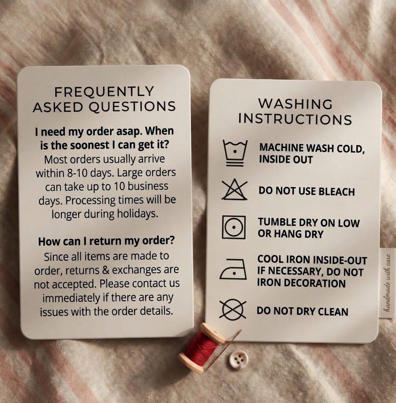 May include: Two white cards with rounded corners. One card reads "FREQUENTLY ASKED QUESTIONS" and the other reads "WASHING INSTRUCTIONS". A spool of red thread and a button are at the bottom. The cards provide care and order information.
