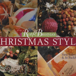 May include: A book cover titled "Ruby & Begonia's Christmas Style" with a red banner. The image features Christmas ornaments, decorations, and text. The authors are Sara Toliver and Jo Packham. The overall theme is holiday decor.