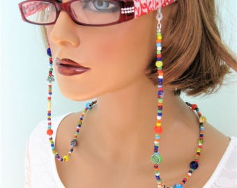 May include: A colorful beaded eyeglass chain with a variety of beads, including round, square, and cylindrical shapes. The chain is attached to the temples of a pair of red glasses.