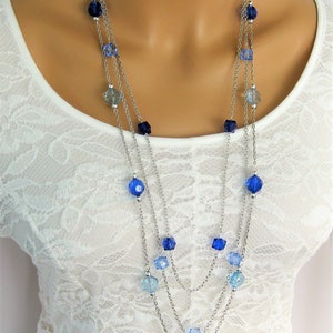 Peut inclure: Un collier à plusieurs rangs avec des chaînes argentées et des perles de verre facettées bleues et bleu clair.