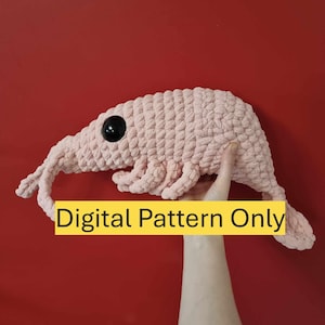 Può includere: Un giocattolo di peluche rosa all'uncinetto a forma di gambero. Il giocattolo ha un occhio nero e il testo "Digital Pattern Only" è visibile nell'immagine.