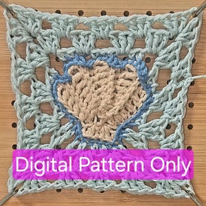 May include: A square crochet piece with a seashell design. The seashell is beige, outlined in blue, and set against a light blue background. The text "Digital Pattern Only" is displayed on a pink banner.