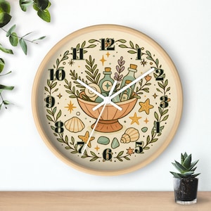 May include: A round wall clock with a light wood frame. The clock face features a beige background with a botanical illustration of a bowl filled with bottles and plants. The clock hands are white, and the numbers are in a stylized font.